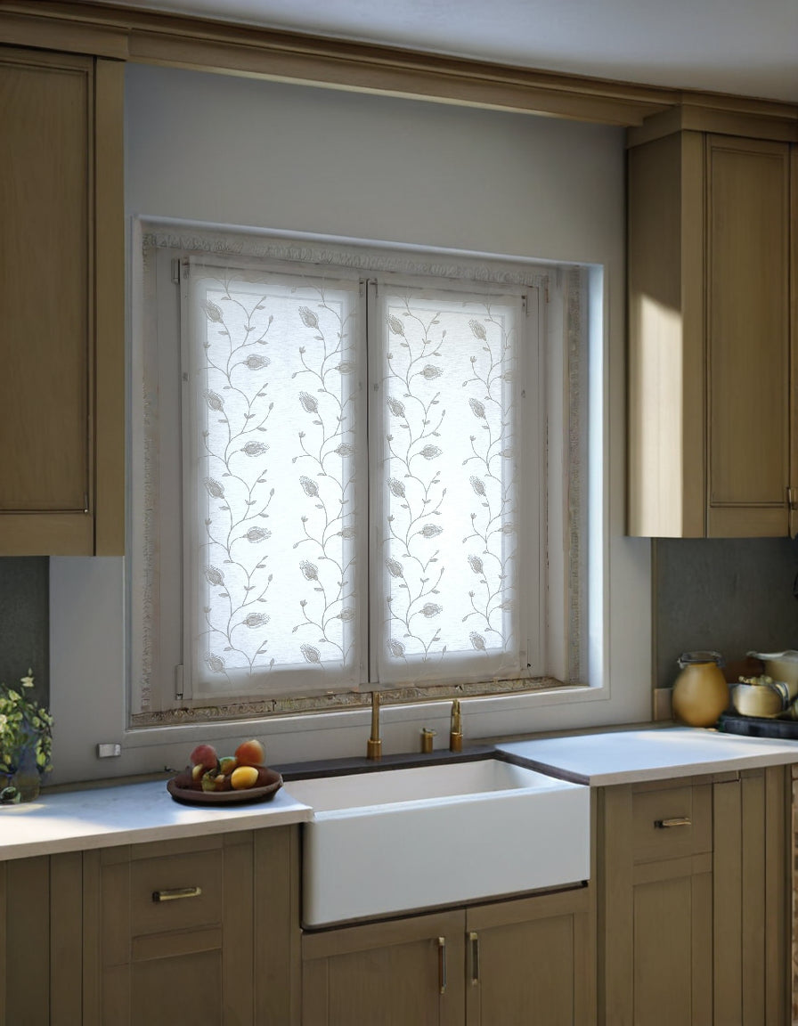 Tende bianche ricamate con motivi di calla, installate su una finestra in una cucina dallo stile moderno