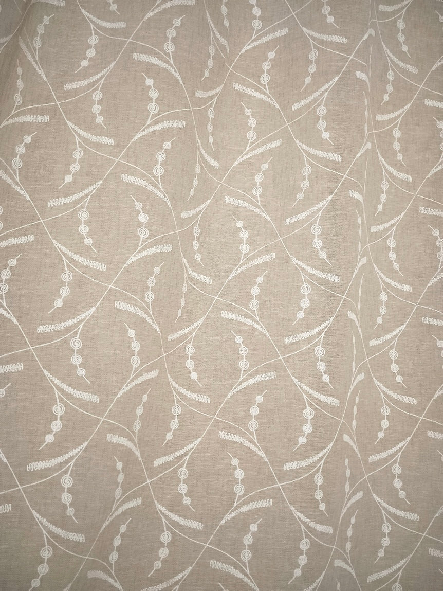 Dettaglio tessuto effetto lino colore lino con ricamo bianco