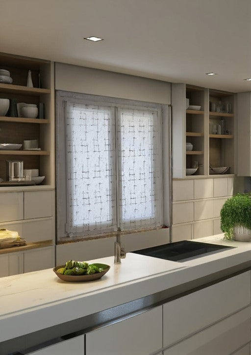 Coppia di tende bianche appese a una finestra in una cucina luminosa