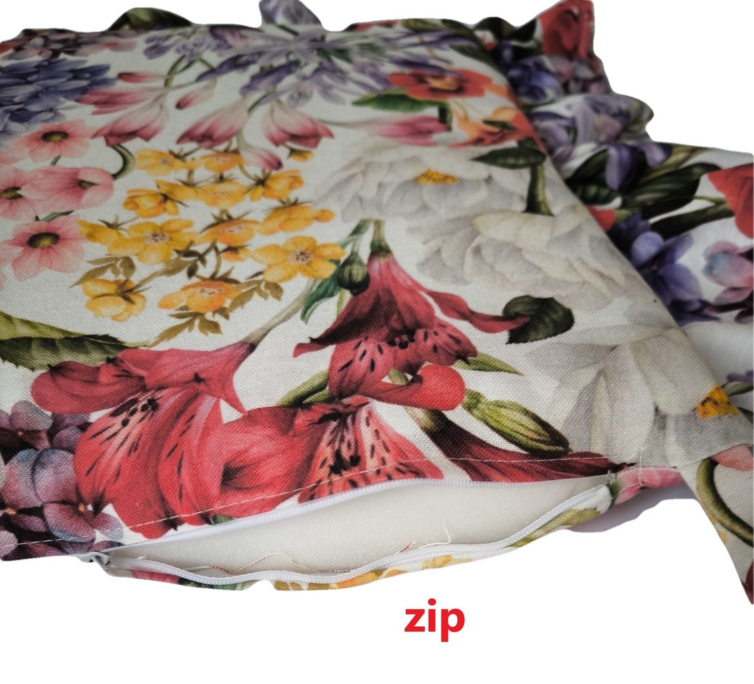 Primo piano della zip di un cuscino a fantasia floreale multicolor con volant, che permette di rimuovere l’imbottitura per lavaggio.