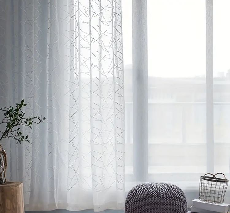 Trasparenza della tenda bianca davanti a una finestra, effetto luce naturale.