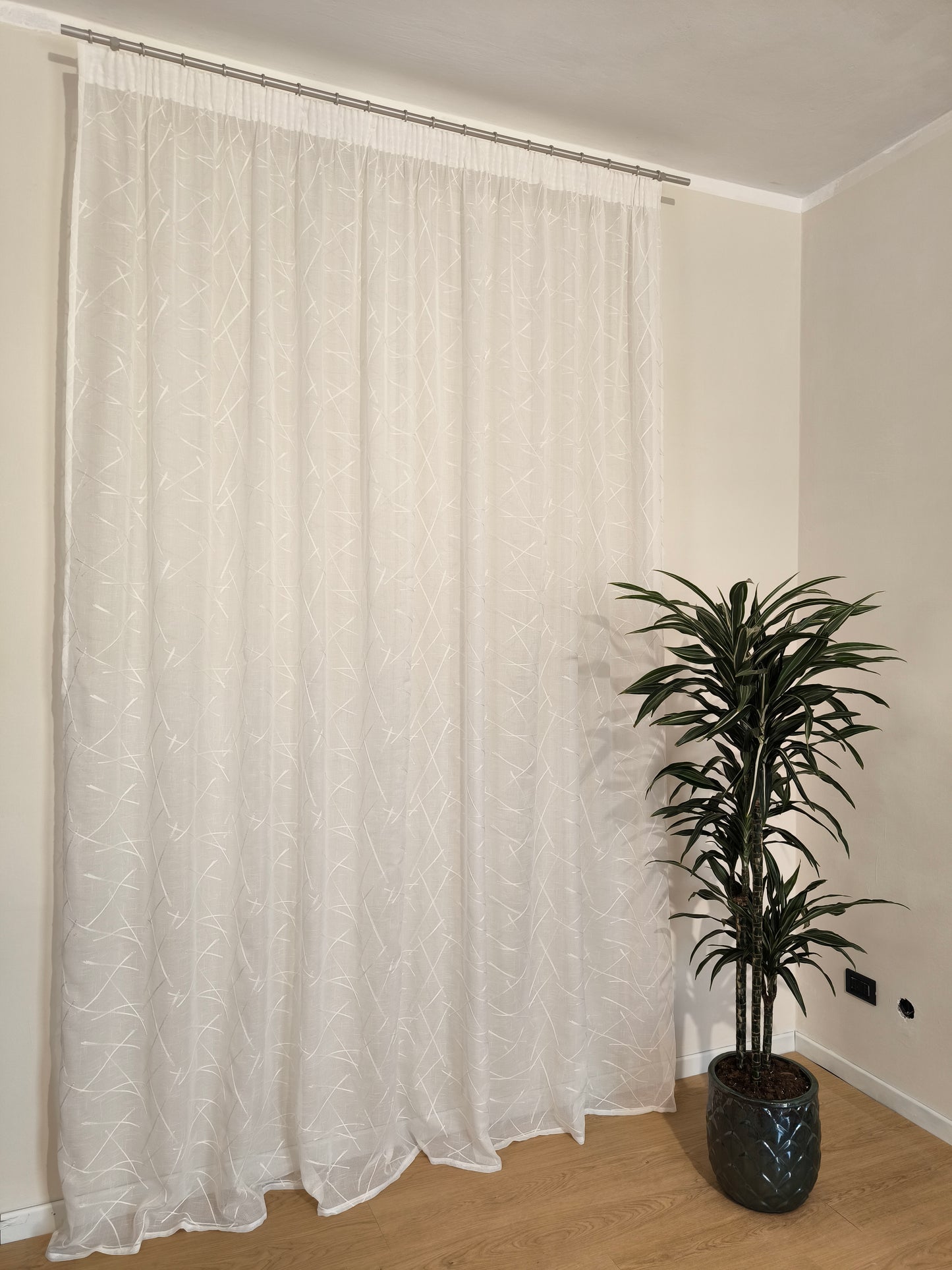 Rideau blanc naturel avec broderie ton sur ton sur tissu de rideau.