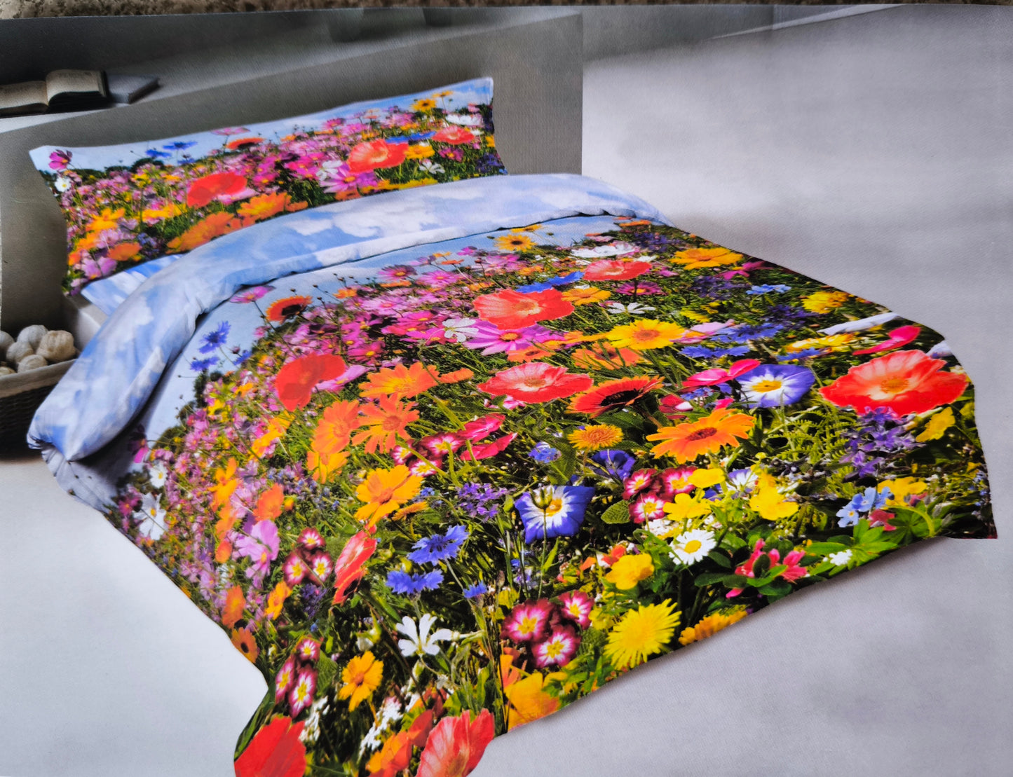 Lenzuolo copriletto prato fiorito in 100% cotone, steso su un letto matrimoniale. Stampa digitale con prato primaverile fiorito e balza coordinata.