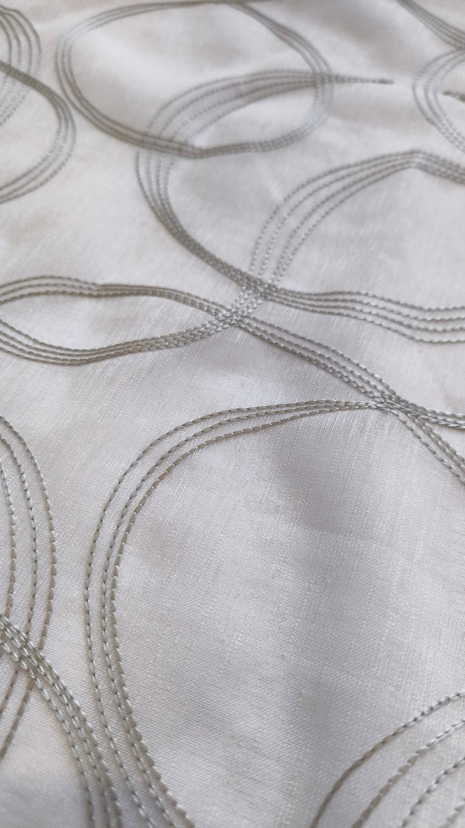 Tessuto bianco con ricamo grigio