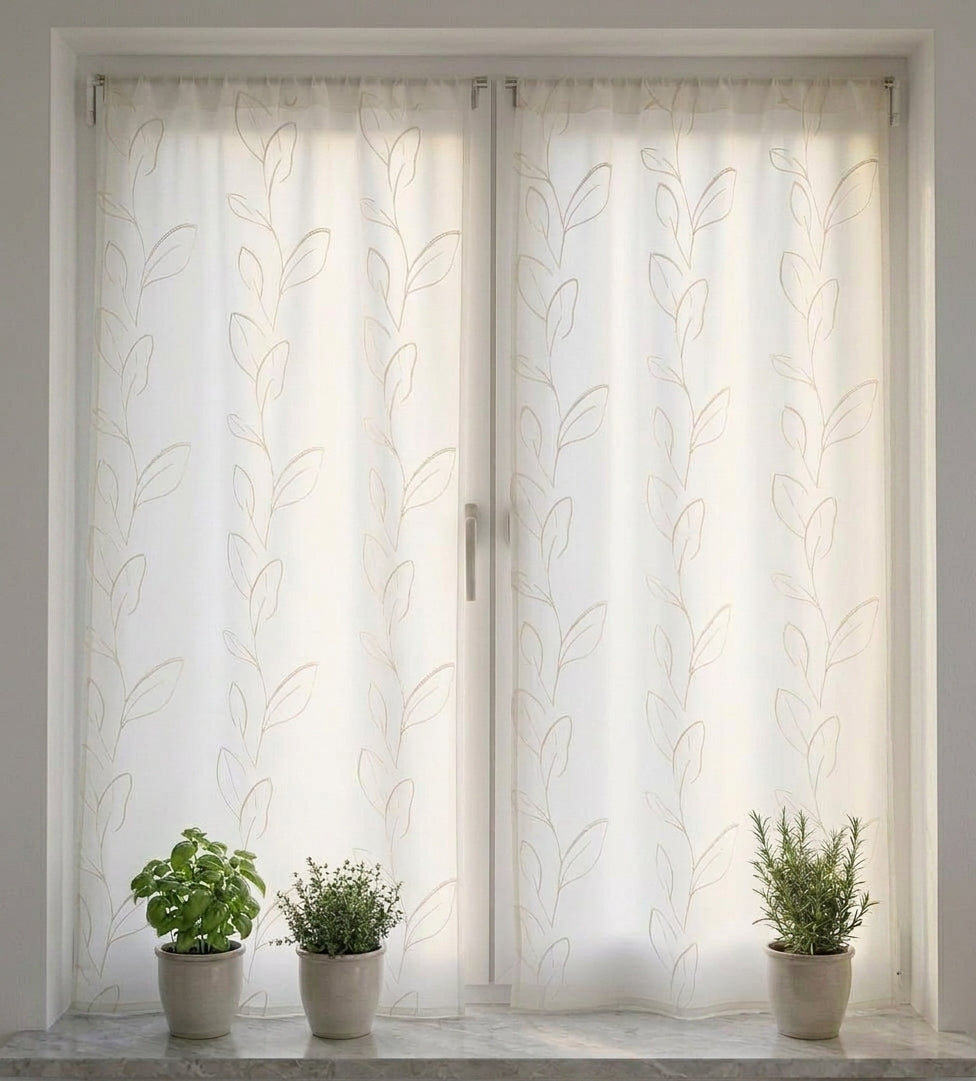 Coppia di tende effetto lino bianco ricamate con foglia stilizzata, installate su una finestra.