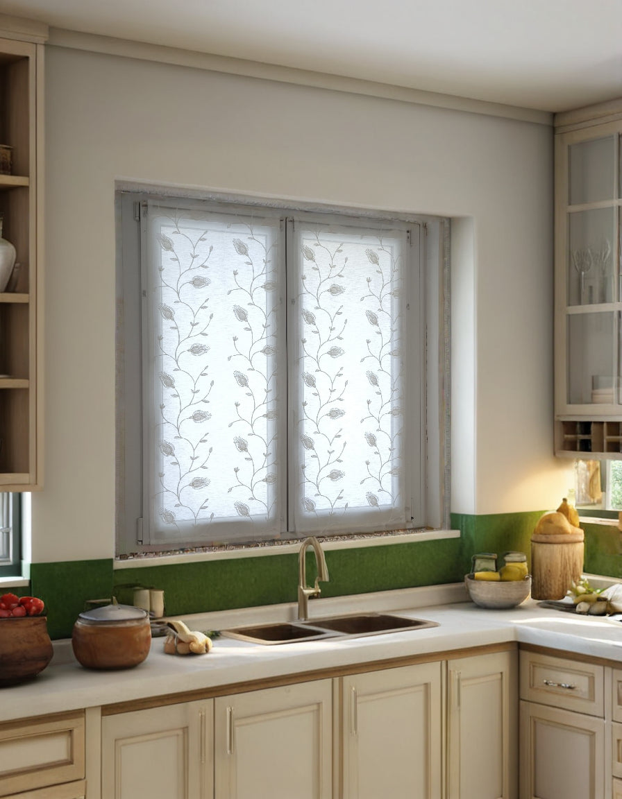 Vista laterale della tenda bianca con ricamo di calla in una cucina luminosa