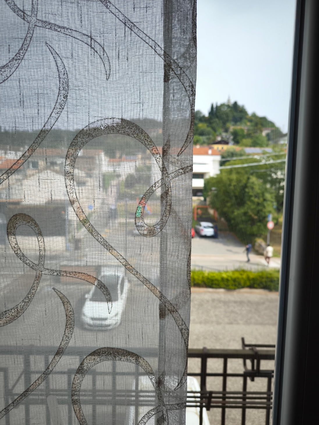Tessuto tenda effetto lino bianco e marrone con stampa geometrica, visibile la trasparenza.