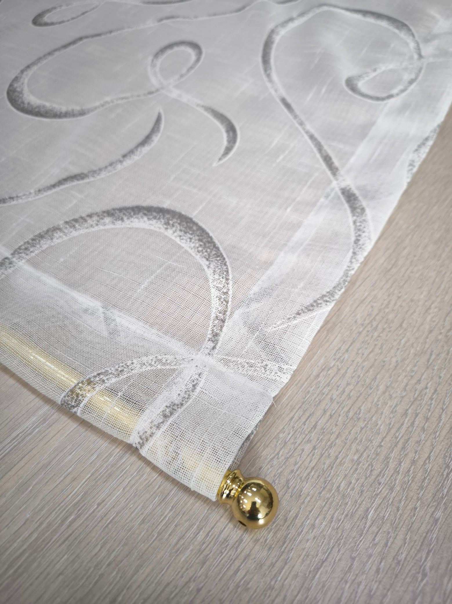 Tenda bianca e grigio con fantasia geometrica ed effetto lino, dettaglio della tasca per bastoncino.