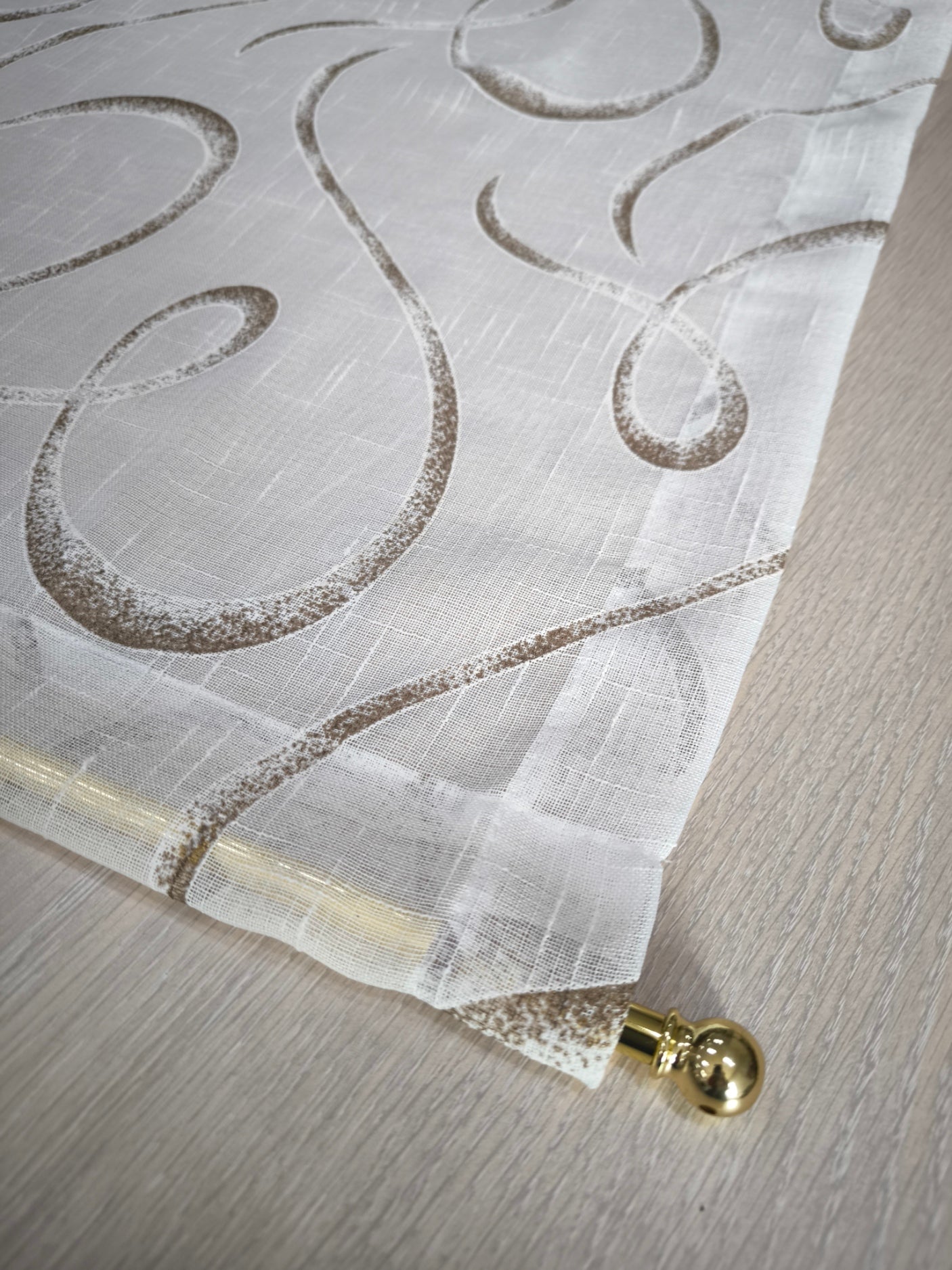 Tenda bianca e marrone con fantasia geometrica ed effetto lino, dettaglio della tasca per bastoncino.