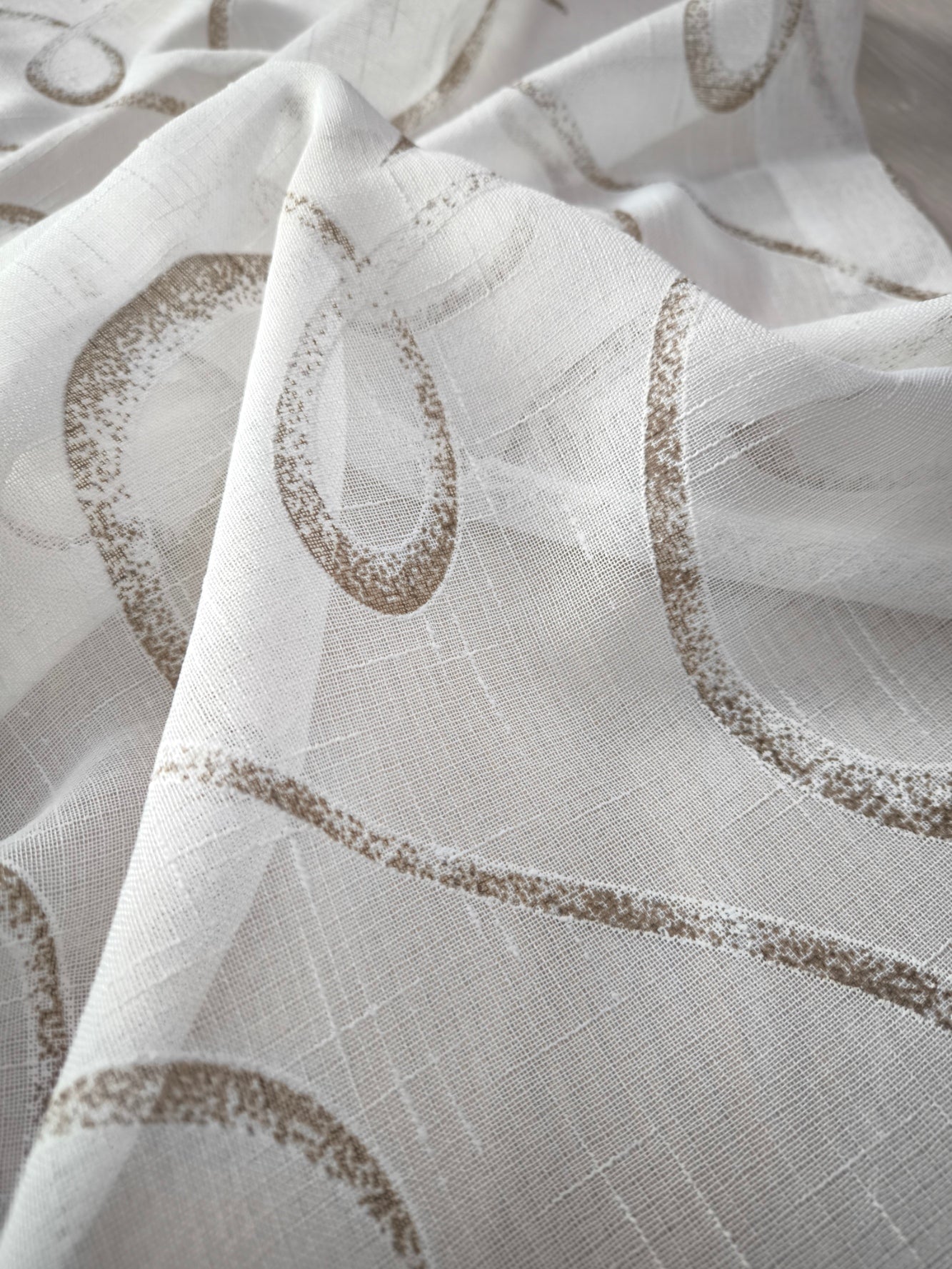 Dettaglio tessuto tenda effetto lino bianco e marrone con fantasia geometrica.