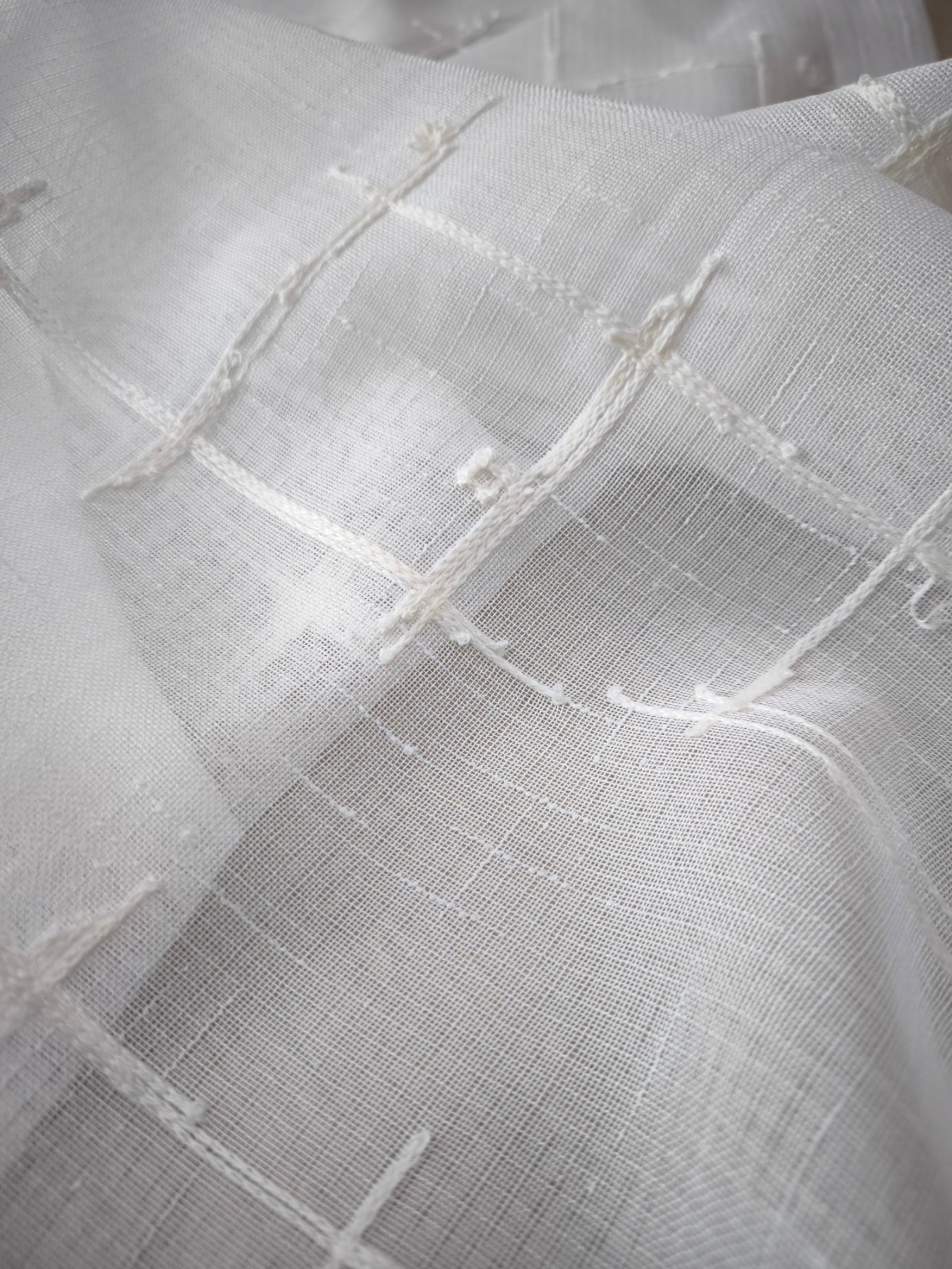 Particolare del ricamo su tessuto bianco della tenda